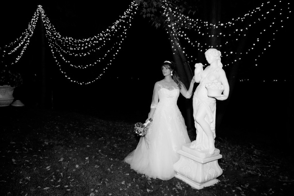la mariée Sophie devant une statue le soir au chateau Vaudreuil