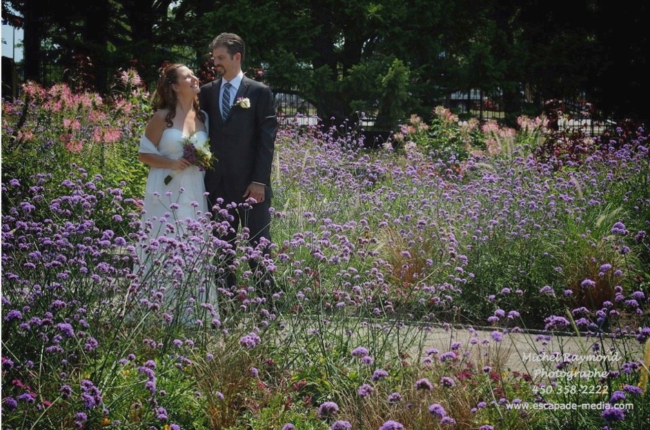 couple marié près des fleurs de l'entrée du jardin botanique