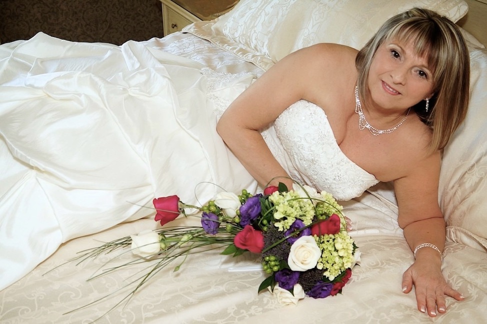 La mariée étendu dans dans le lit avec le bouquet au Château Vaudreuil