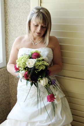 La mariée avec sson bouquet près de la fenêtre
